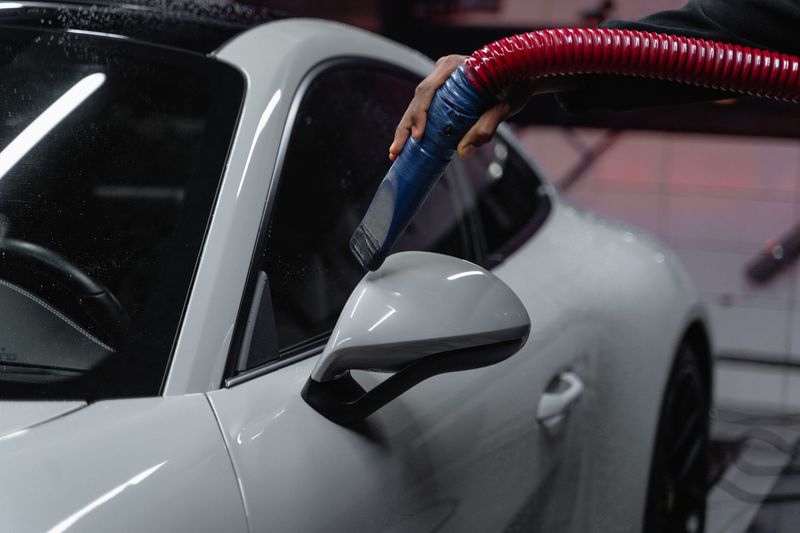 Detailer polishing a vehicle during professional car detailing